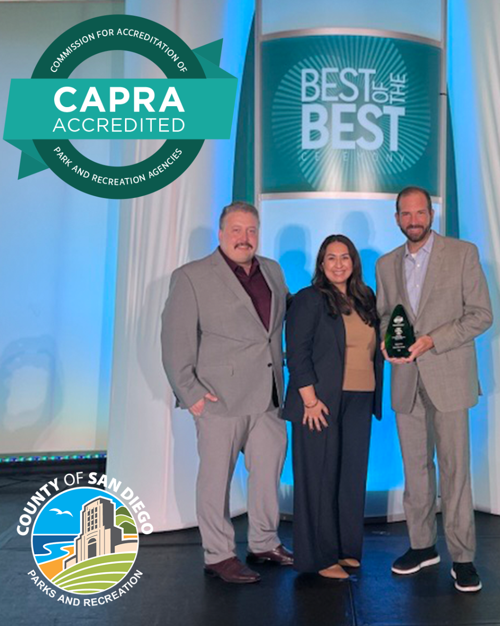 CAPRA Seal on photo of Parks and Recreation leadership team accepting the CAPRA REaccreditation award