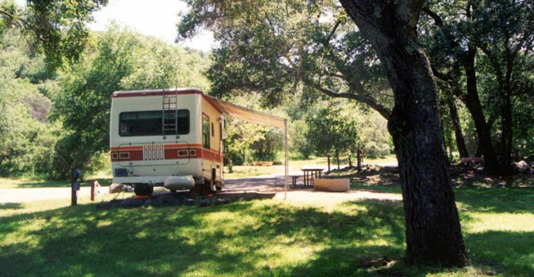 RV in the middle of camp site with partial-hookup